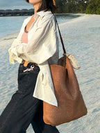Bolso de rafia marrón con asas largas de cuero y saquito beige colgante
