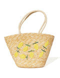 Bolso tipo tote de rafia beige con bordado de limones y asas trenzadas.