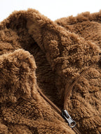 Chaqueta teddy marrón con cremallera y detalle de etiqueta en el cierre