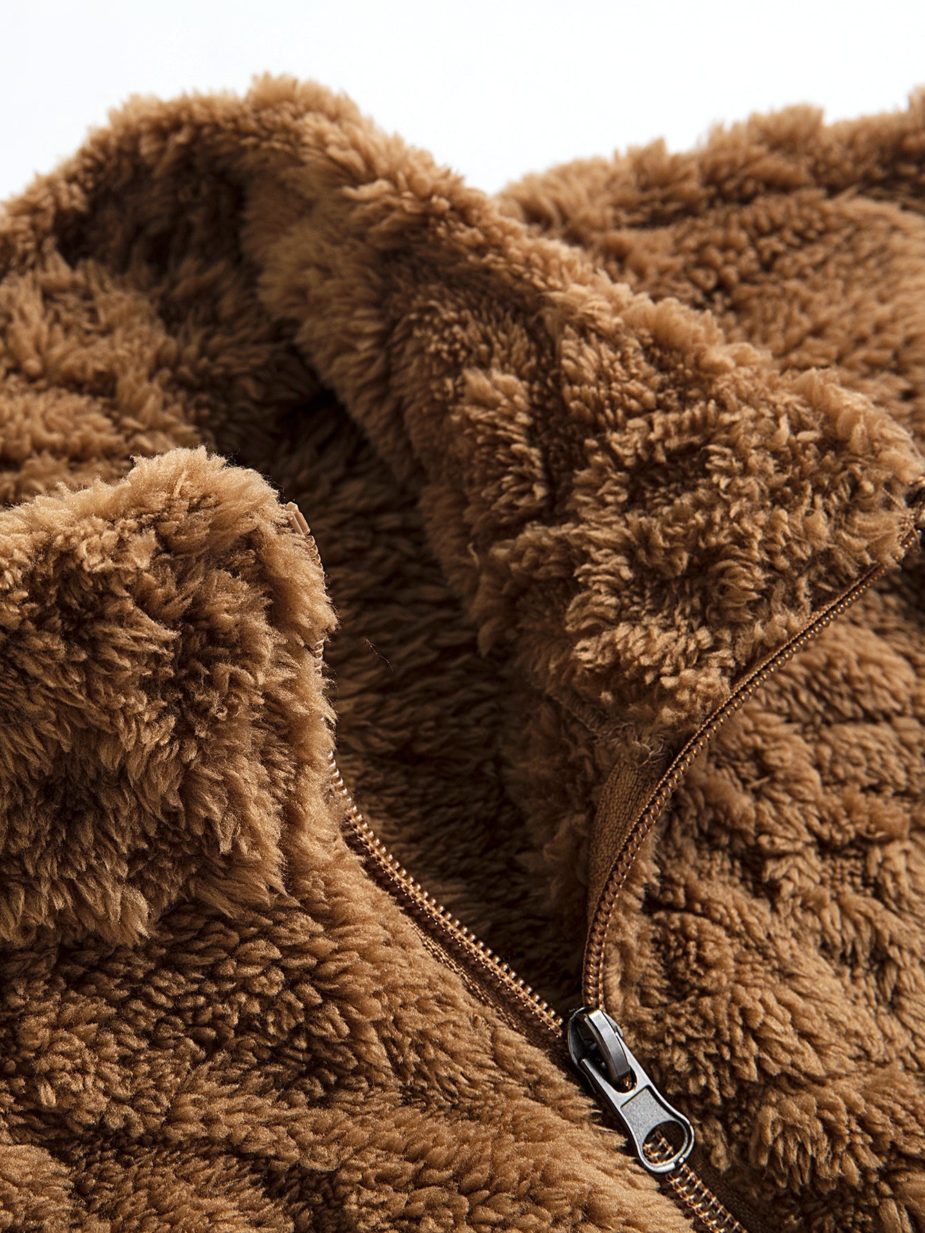 Chaqueta teddy marrón con cremallera y detalle de etiqueta en el cierre