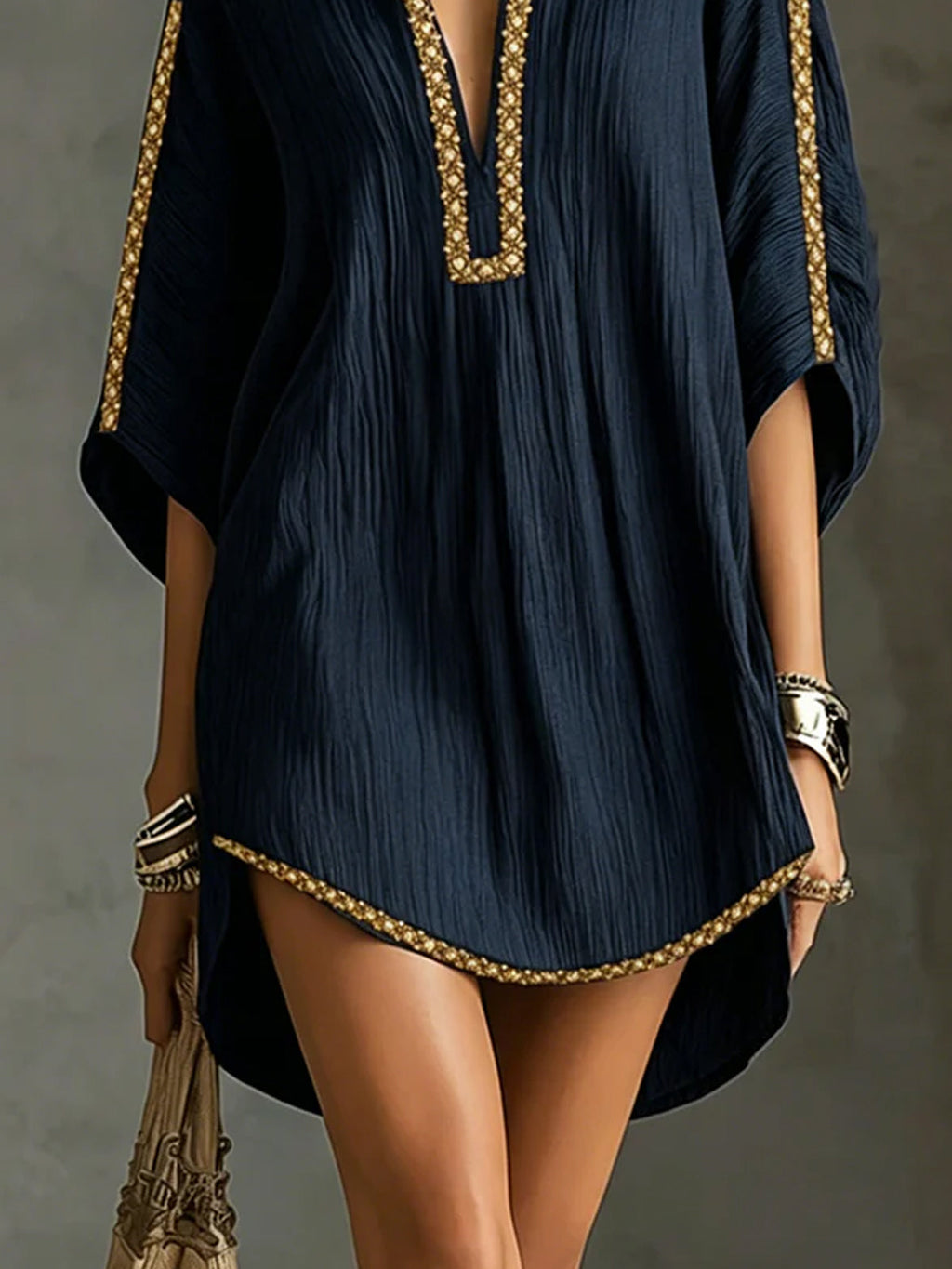Vestido corto azul oscuro con dobladillo ondulado y ribete dorado, tejido acanalado