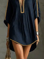 Vestido corto azul oscuro con dobladillo ondulado y ribete dorado, tejido acanalado