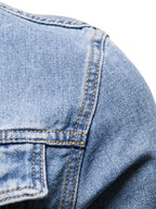Detalle de chaqueta de mezclilla azul claro: costuras en bolsillo y panel frontal