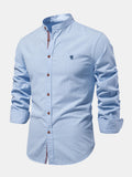 Camisa Ravello azul claro con cuello mao, tapeta con botones marrón y bordado al pecho