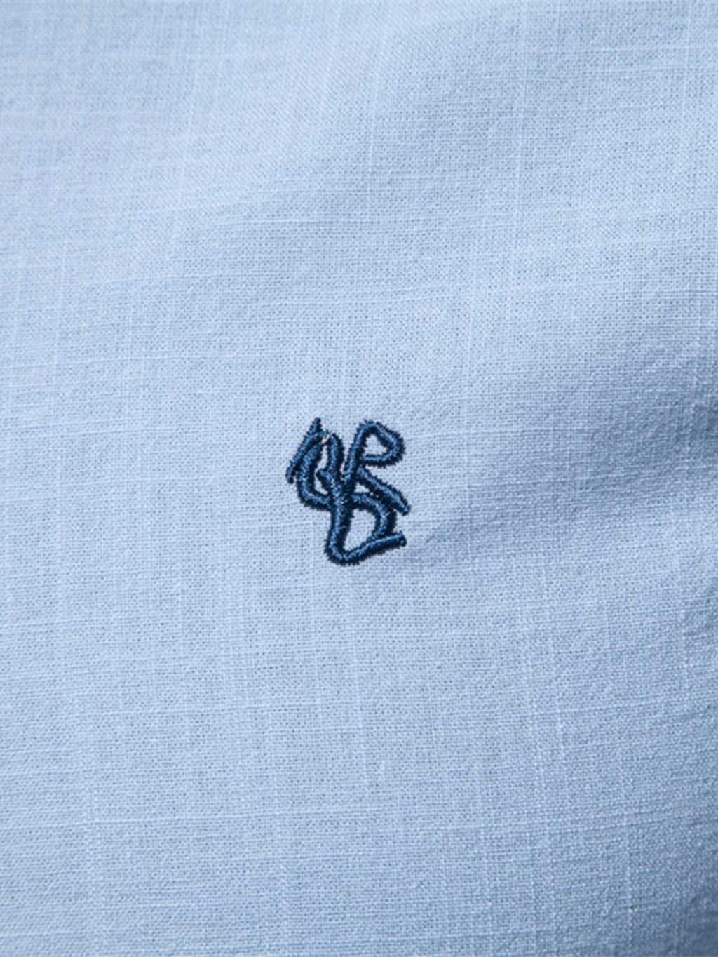 Camisa Ravello azul claro: detalle de bordado pequeño en el pecho y textura de tela