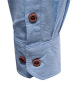 Camisa azul clara con botones en el puño y frunces en la manga