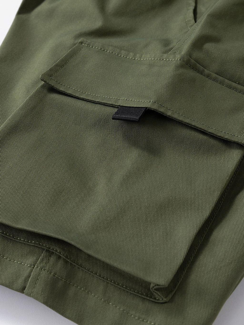 Pantalón corto verde oscuro con solapa de bolsillo y pespuntes visibles