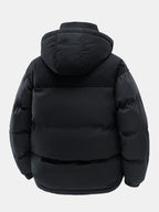 Chaqueta acolchada negra con capucha, vista trasera; acolchado por paneles y puños elásticos.