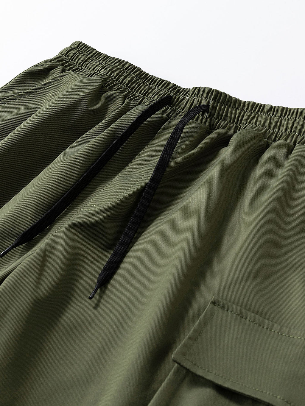 Pantalón corto verde oscuro: cintura elástica con cordón y bolsillo cargo lateral.
