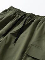 Pantalón corto verde oscuro: cintura elástica con cordón y bolsillo cargo lateral.