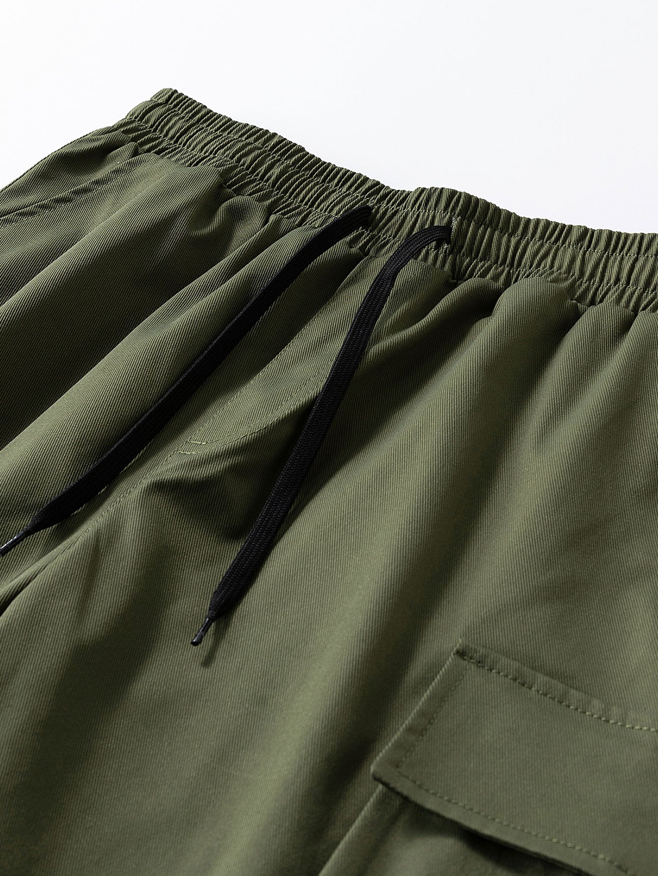 Pantalón corto verde oscuro: cintura elástica con cordón y bolsillo cargo lateral.