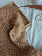 Bolso de rafia marrón por dentro: forro beige y botón a presión metálico