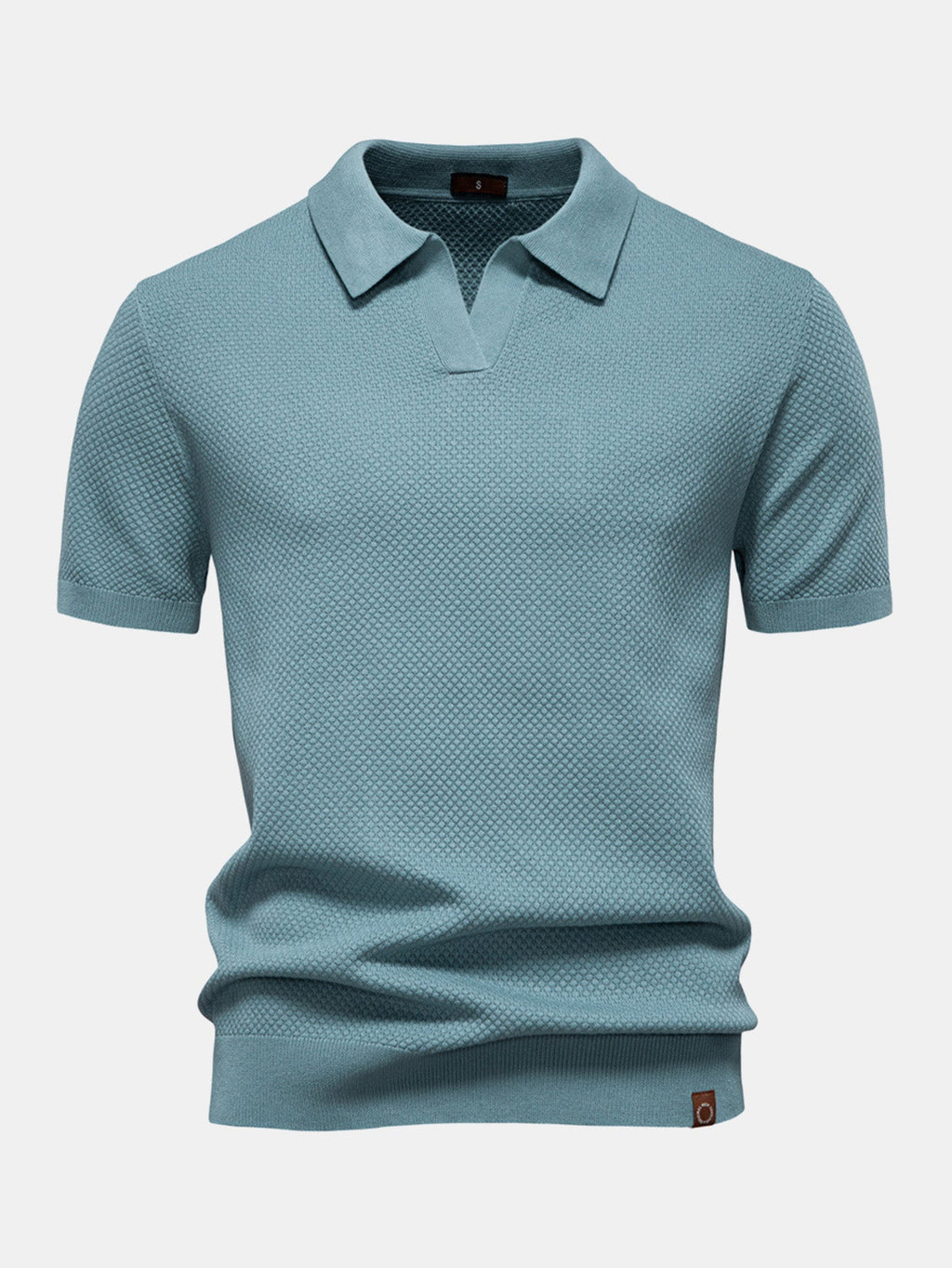 Polo de manga corta color cian, cuello camisero y pliegue en el bajo.