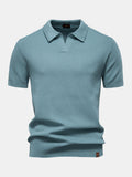 Polo de manga corta color cian, cuello camisero y pliegue en el bajo.