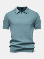 Polo de manga corta color cian, cuello camisero y pliegue en el bajo.