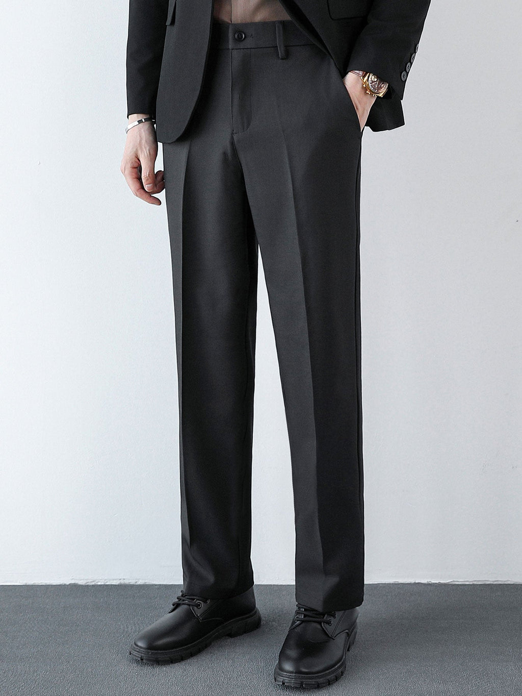 Pantalón regular negro con pliegues sutiles y bolsillos delanteros