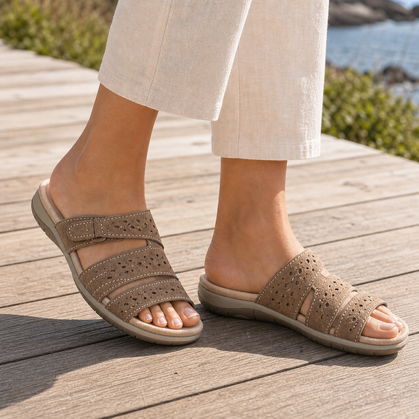 Sandalias de cuero marrón con dos tiras cruzadas, perforaciones y suela acolchada.