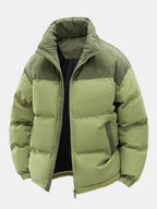 Chaqueta acolchada patchwork verde con capucha, cremallera y acolchado por paneles, tonos oliva.