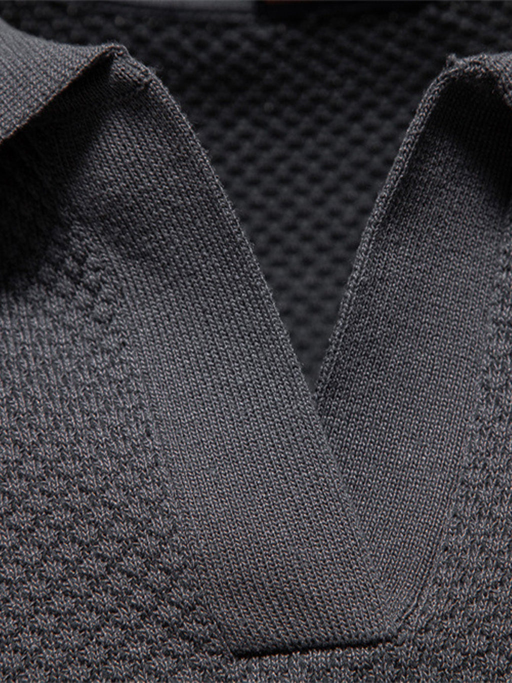 Polo gris oscuro: primer plano del cuello y tejido con textura de punto fino