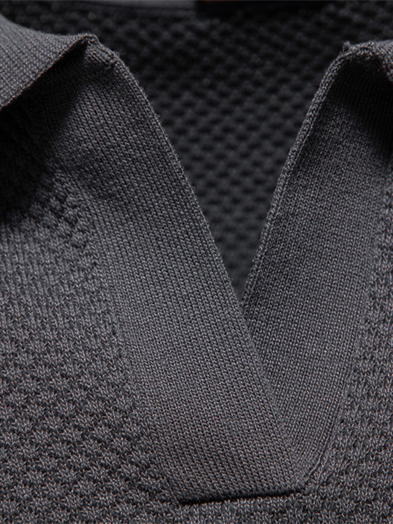 Polo gris oscuro: primer plano del cuello y tejido con textura de punto fino