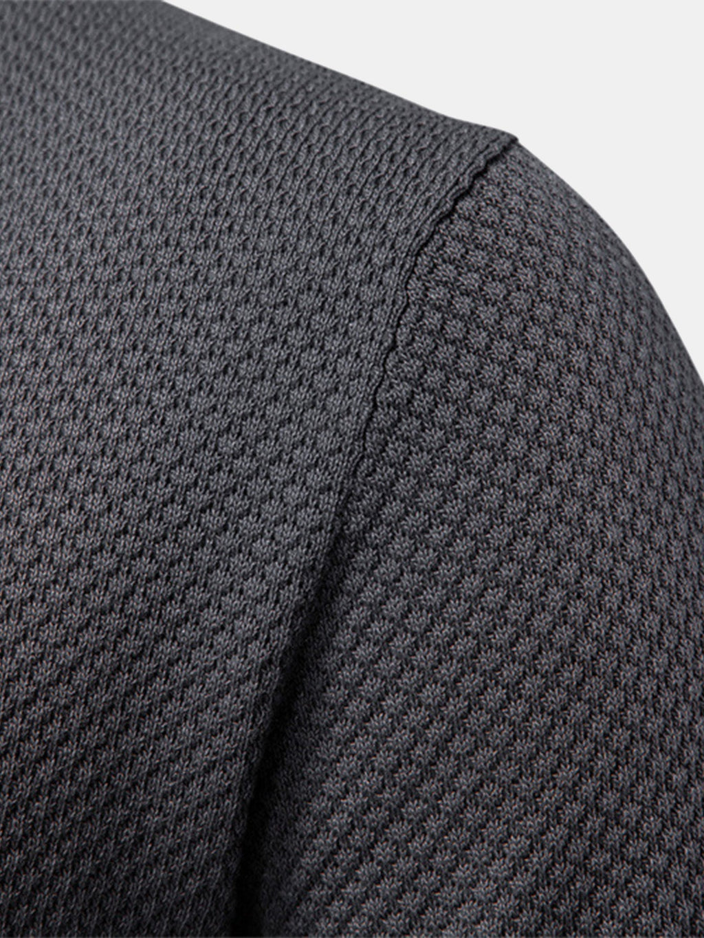 Polo gris oscuro: primer plano del hombro y manga con costura lateral visible