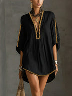 Vestido corto negro con escote en V pronunciado y ribete dorado, manga caftán