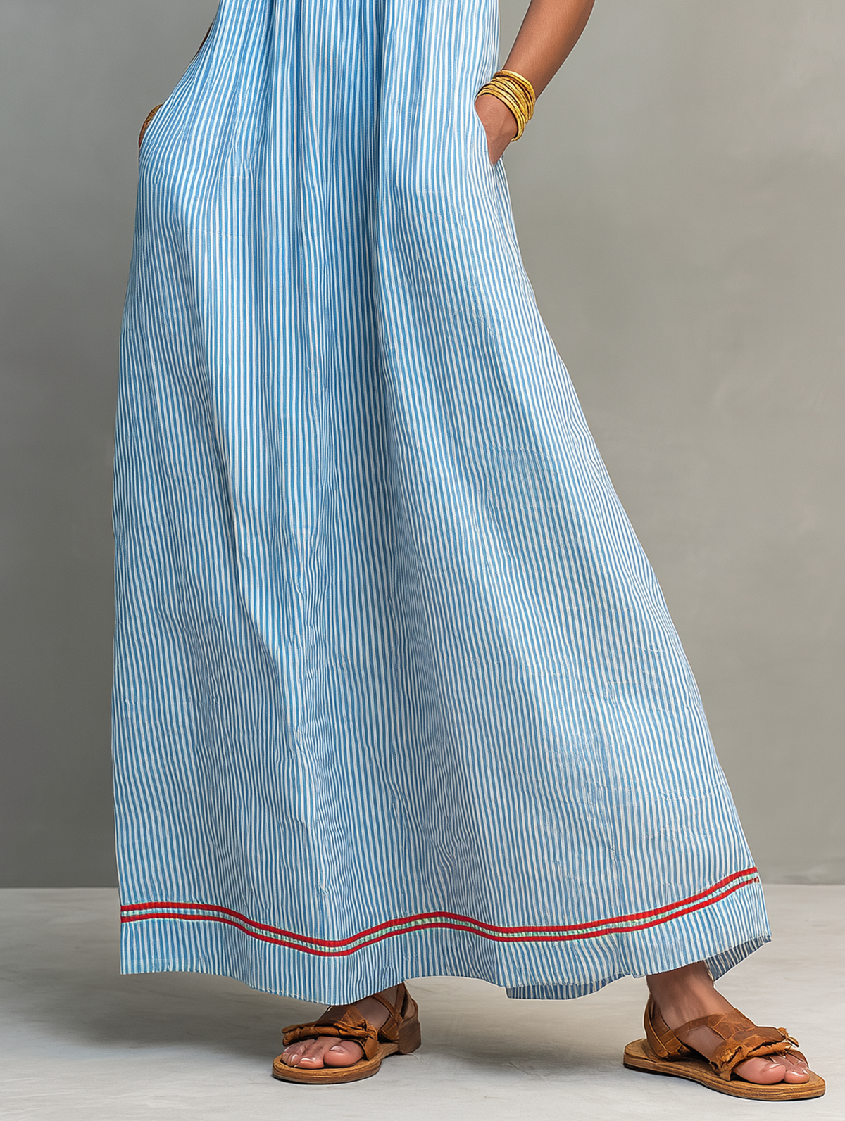 Vestido azul con rayas verticales y bajo acampanado con ribete rojo