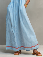 Vestido azul con rayas verticales y bajo acampanado con ribete rojo