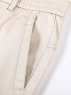 Pantalón recto beige con costuras y cierre con botón decorativo