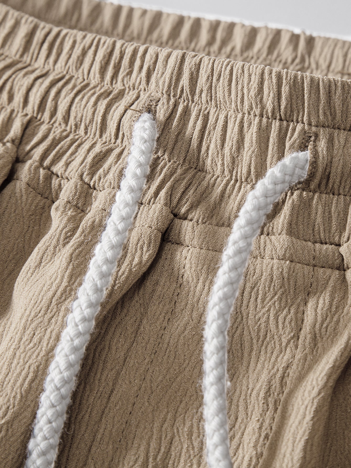 Pantalón corto beige con cintura elástica y cordones blancos