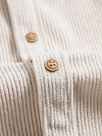 Camisa beige: tapeta con botones de madera y costuras visibles