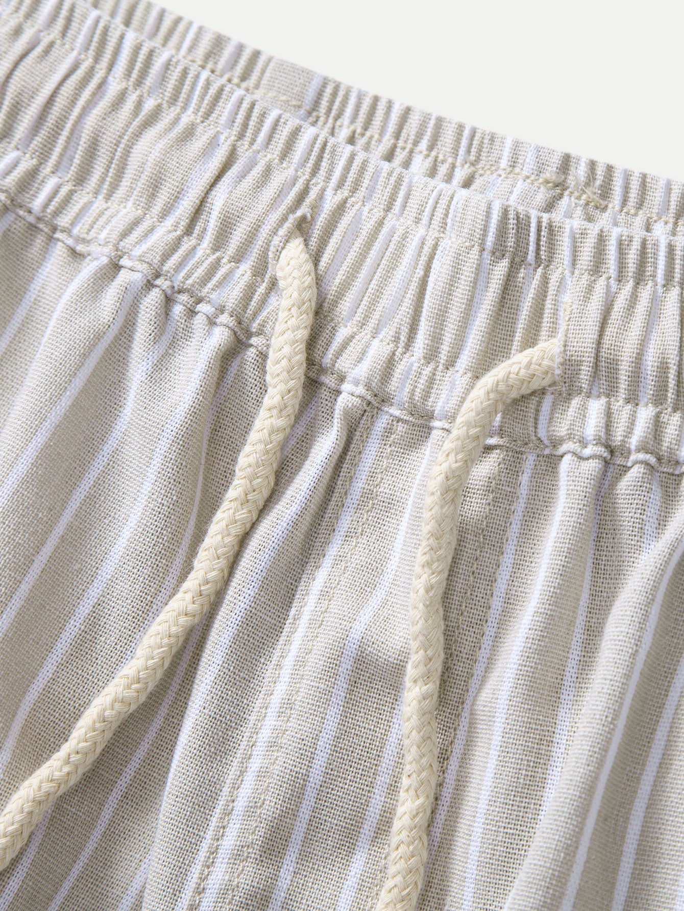 Pantalón de lino a rayas beige en detalle: cintura elástica y cordón
