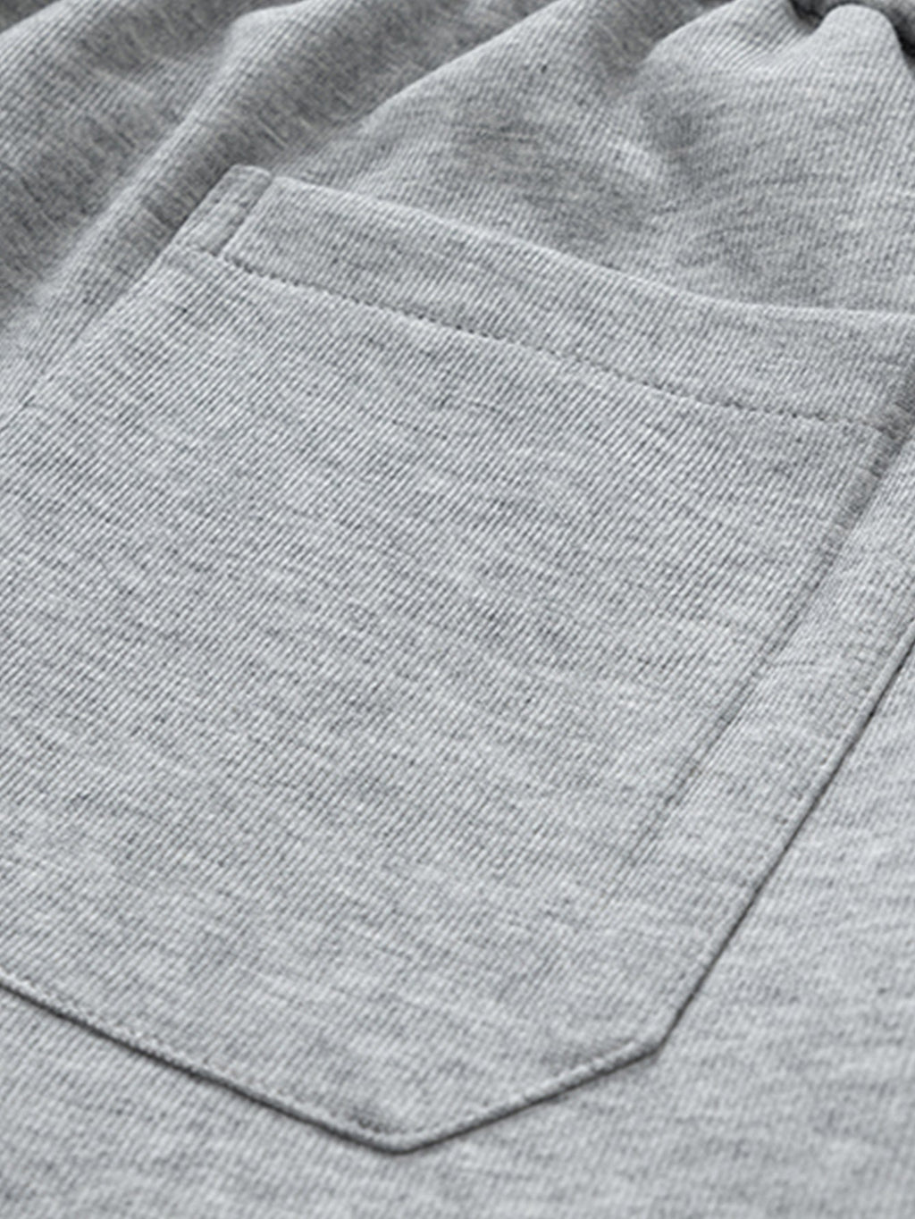 Bolsillo delantero en pantalón cargo gris claro con pespuntes visibles