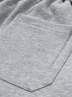 Bolsillo delantero en pantalón cargo gris claro con pespuntes visibles