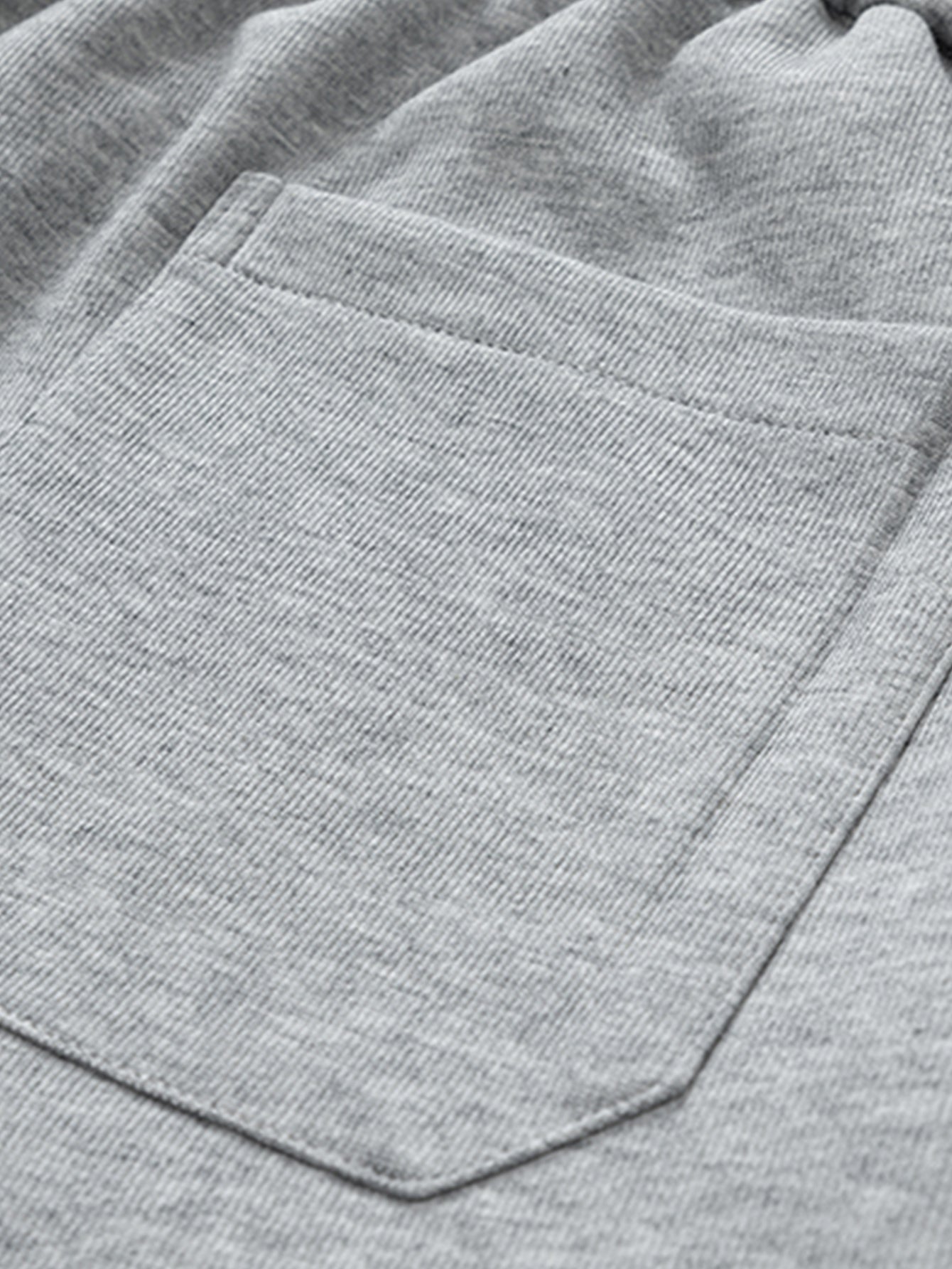Bolsillo delantero en pantalón cargo gris claro con pespuntes visibles