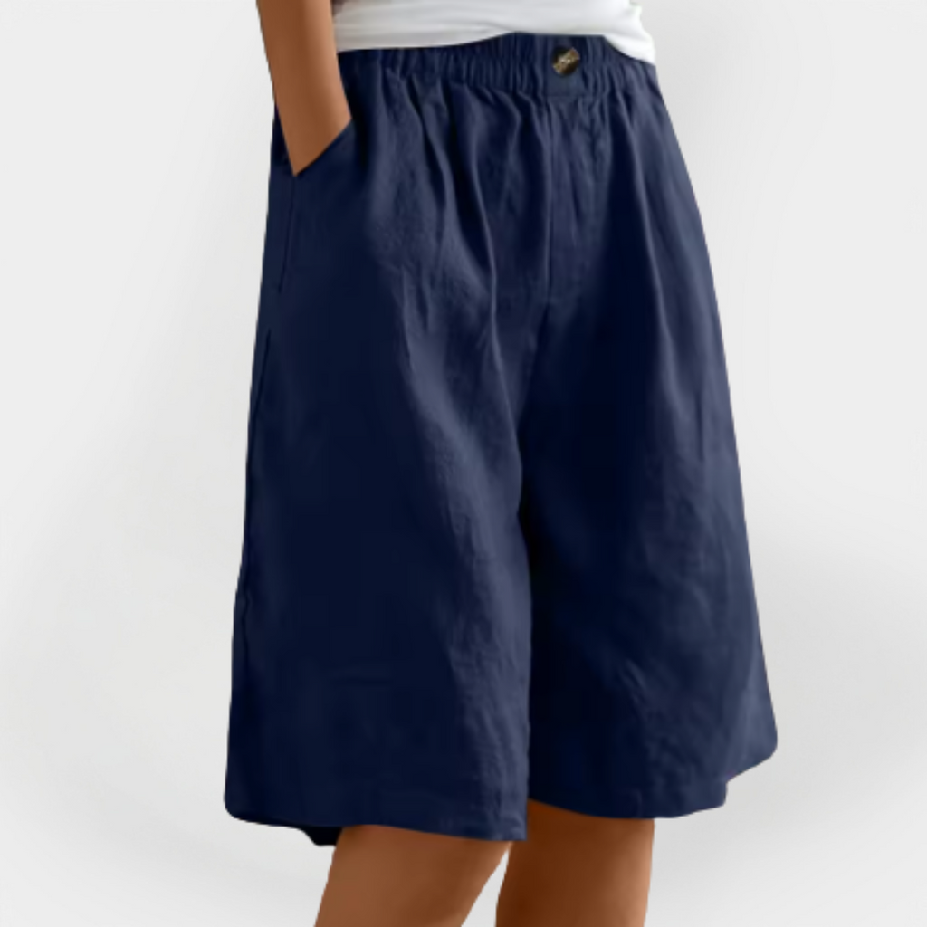 Pantalones efecto lino Valentina azul marino, cintura elástica con botón y pernera ancha a la rodilla.