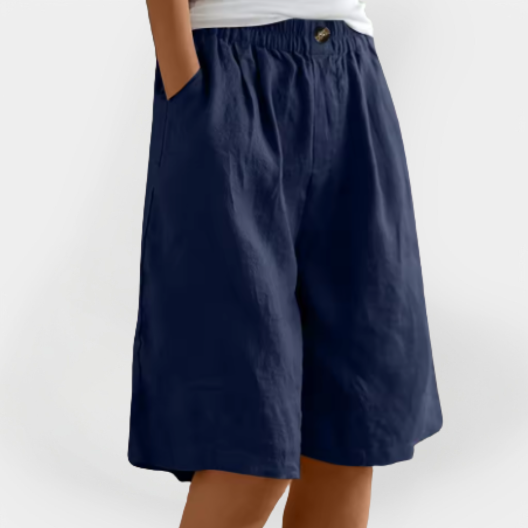 Pantalones efecto lino Valentina azul marino, cintura elástica con botón y pernera ancha a la rodilla.