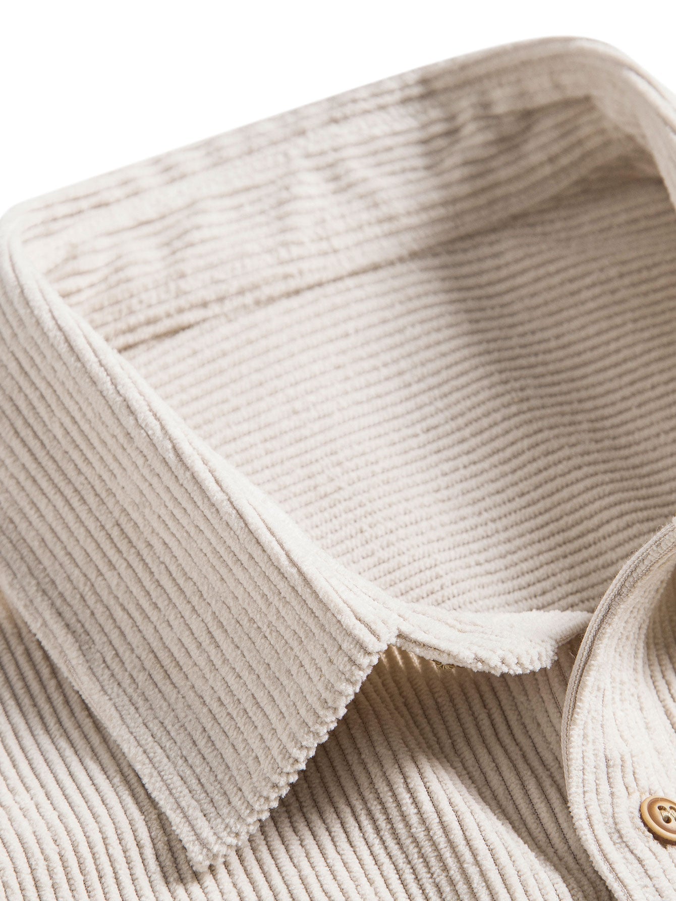 Camisa de tela beige con cuello y tapeta de botones, detalle de la costura
