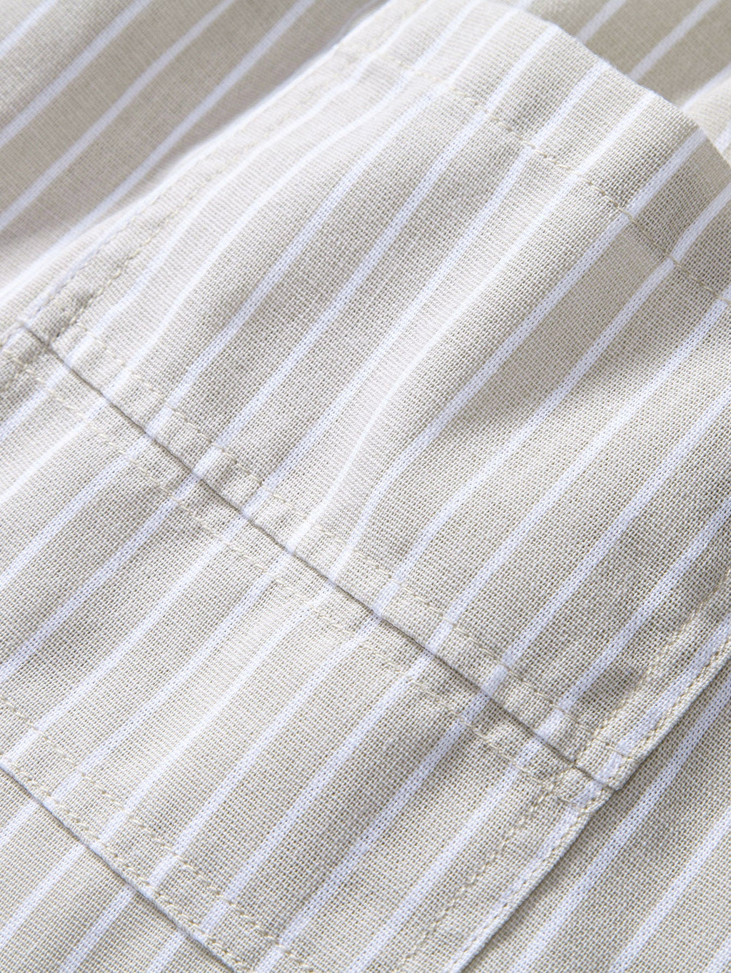 Pantalón de lino a rayas beige en detalle: dobladillo y costuras finas