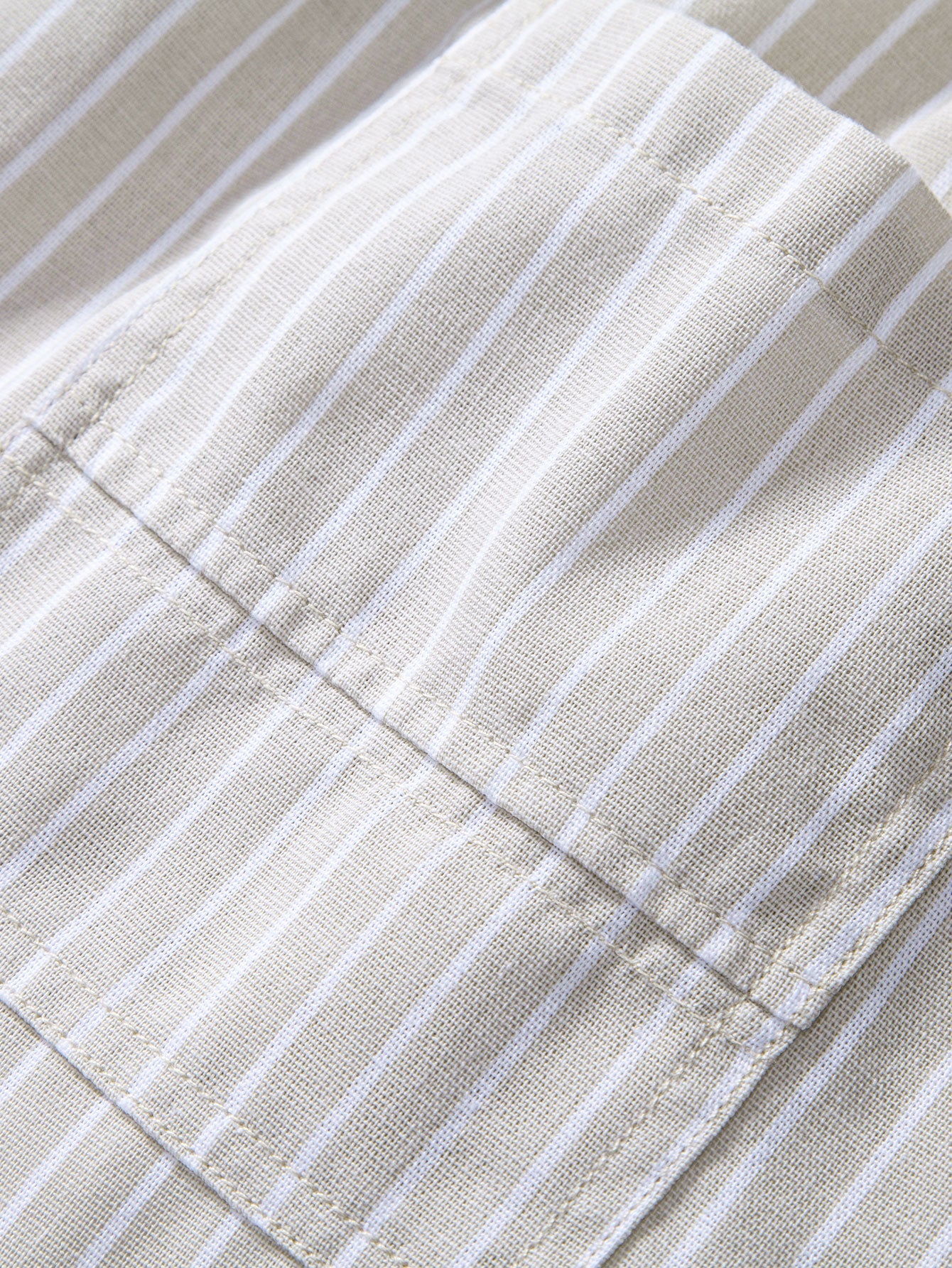 Pantalón de lino a rayas beige en detalle: dobladillo y costuras finas