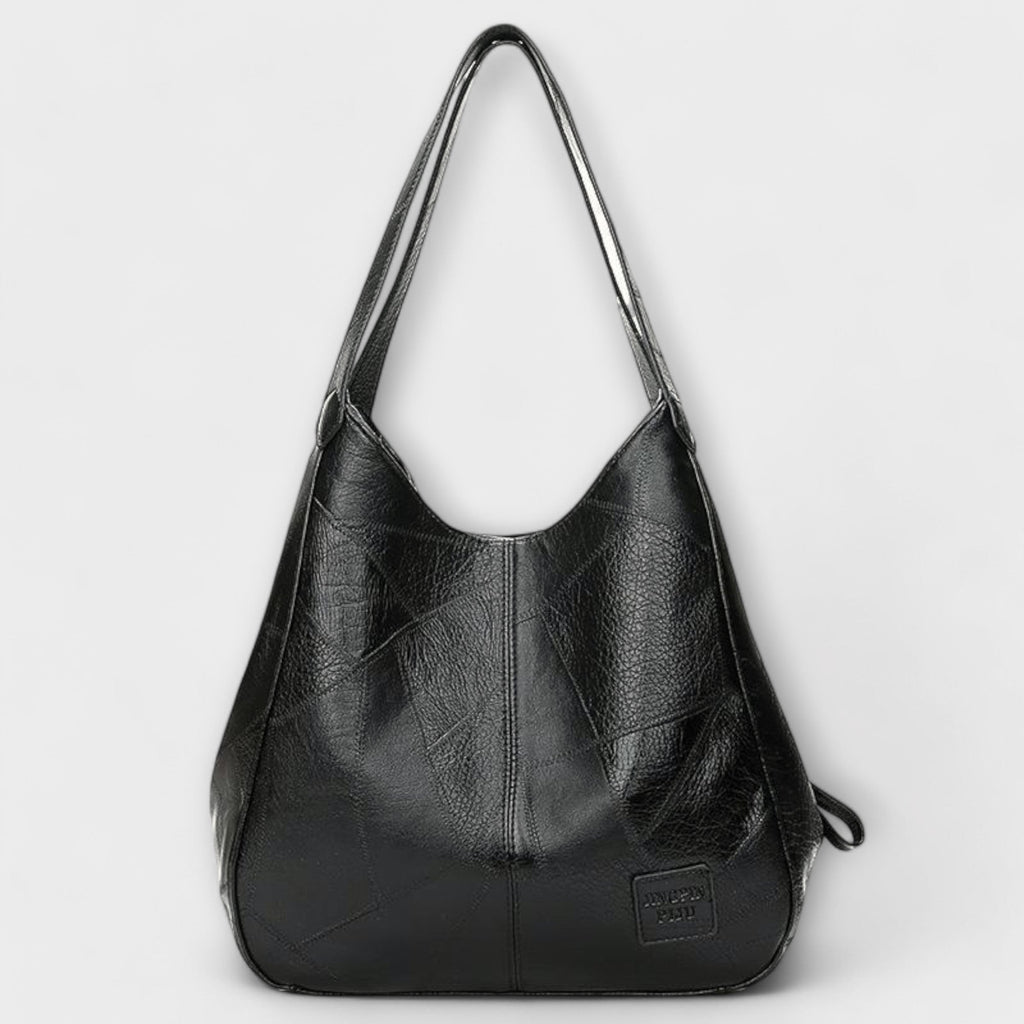 Bolso de piel negro estilo hobo con asas largas y placa en el frente