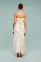 Vestido midi blanco con espalda abierta y tirantes finos con lazo; con volantes.