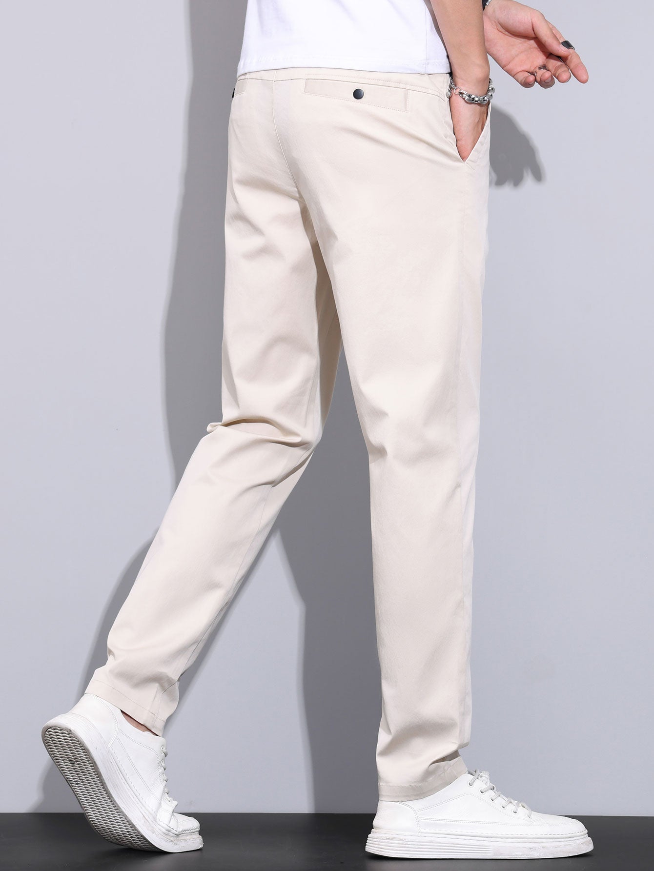 Pantalón recto beige con cintura con presillas, botón y bolsillos frontales