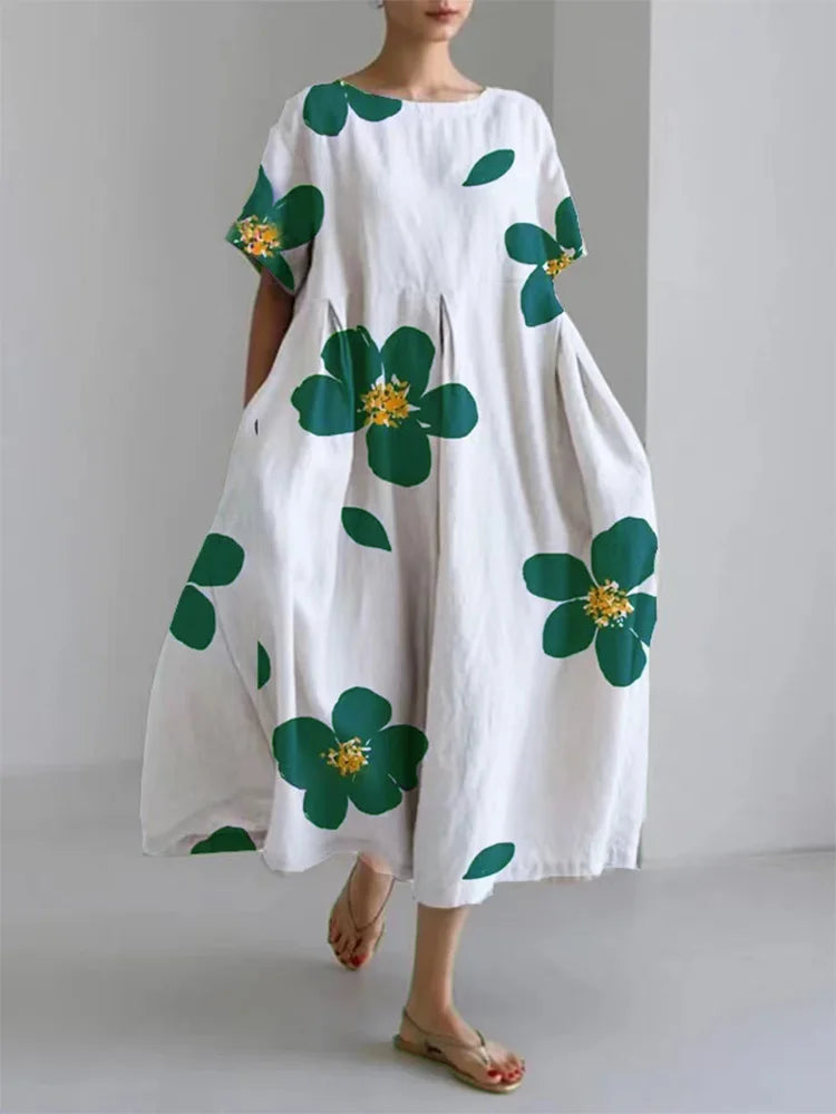Vestido fluido floreal blanco con hojas verdes y flores con centros amarillos, manga corta holgada