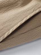 Pantalón corto beige de tela con textura y pliegues