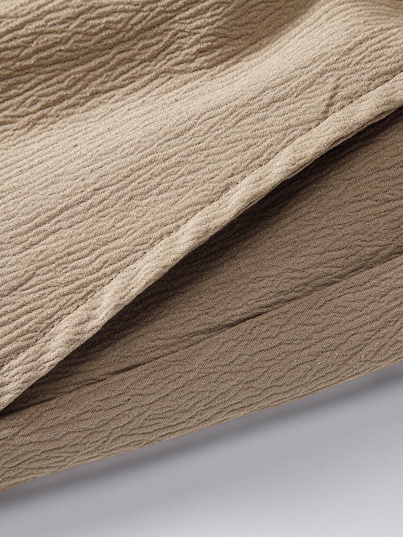 Pantalón corto beige de tela con textura y pliegues