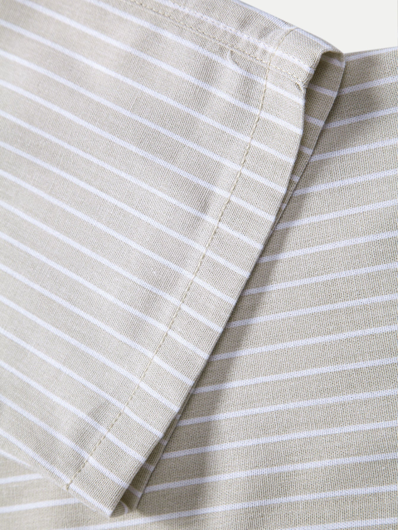 Tela de pantalón de lino a rayas beige, vista de la costura lateral