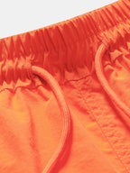 Bañador corto naranja: detalle de cintura elástica y cordón