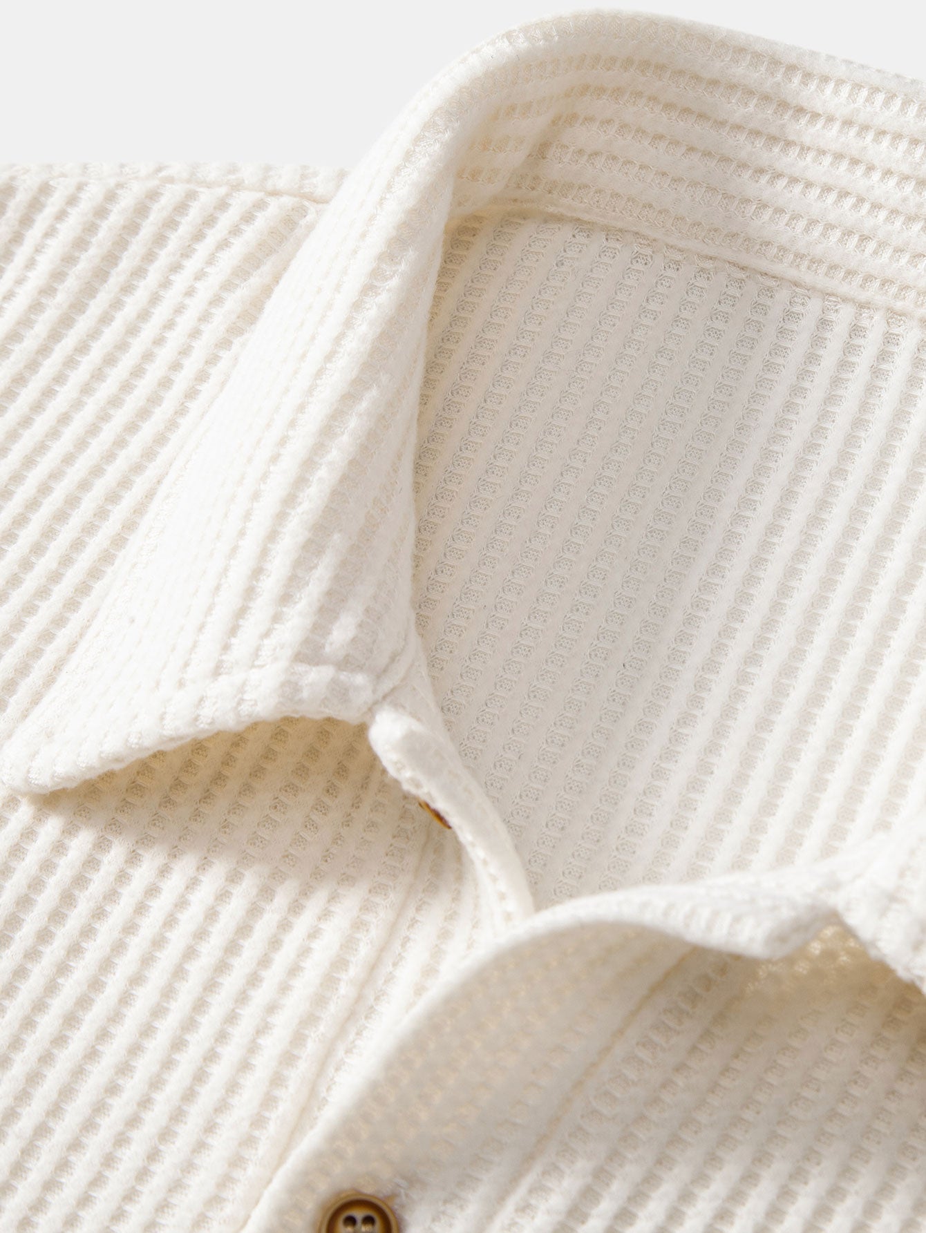 Polo crema de tejido de rizo, cuello y tapeta con botón de madera