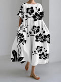 Vestido fluido blanco con estampado floral negro, manga corta y cuello redondo.